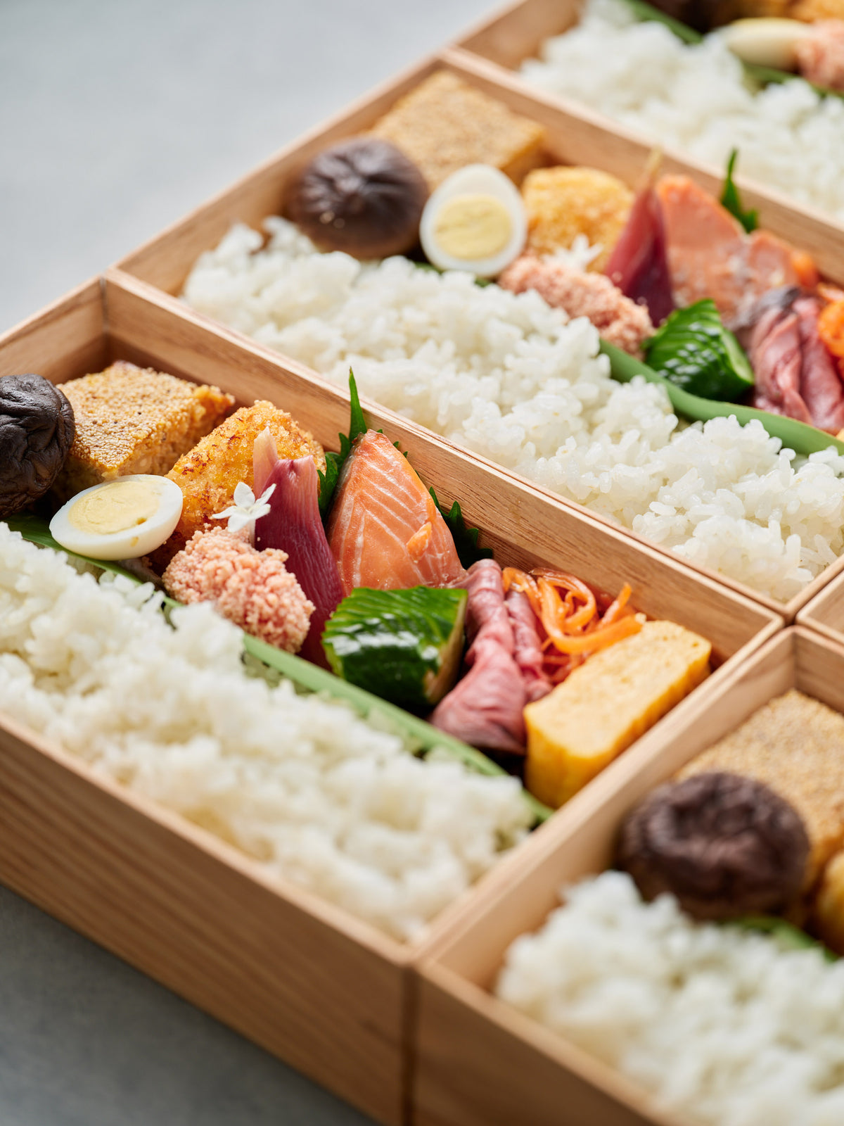 ごはんと季節のおかずを彩りよく詰めた木箱のお弁当