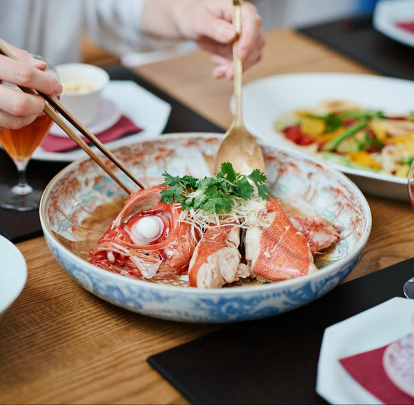 魚とごはんを小さな器に取り分ける食卓の風景