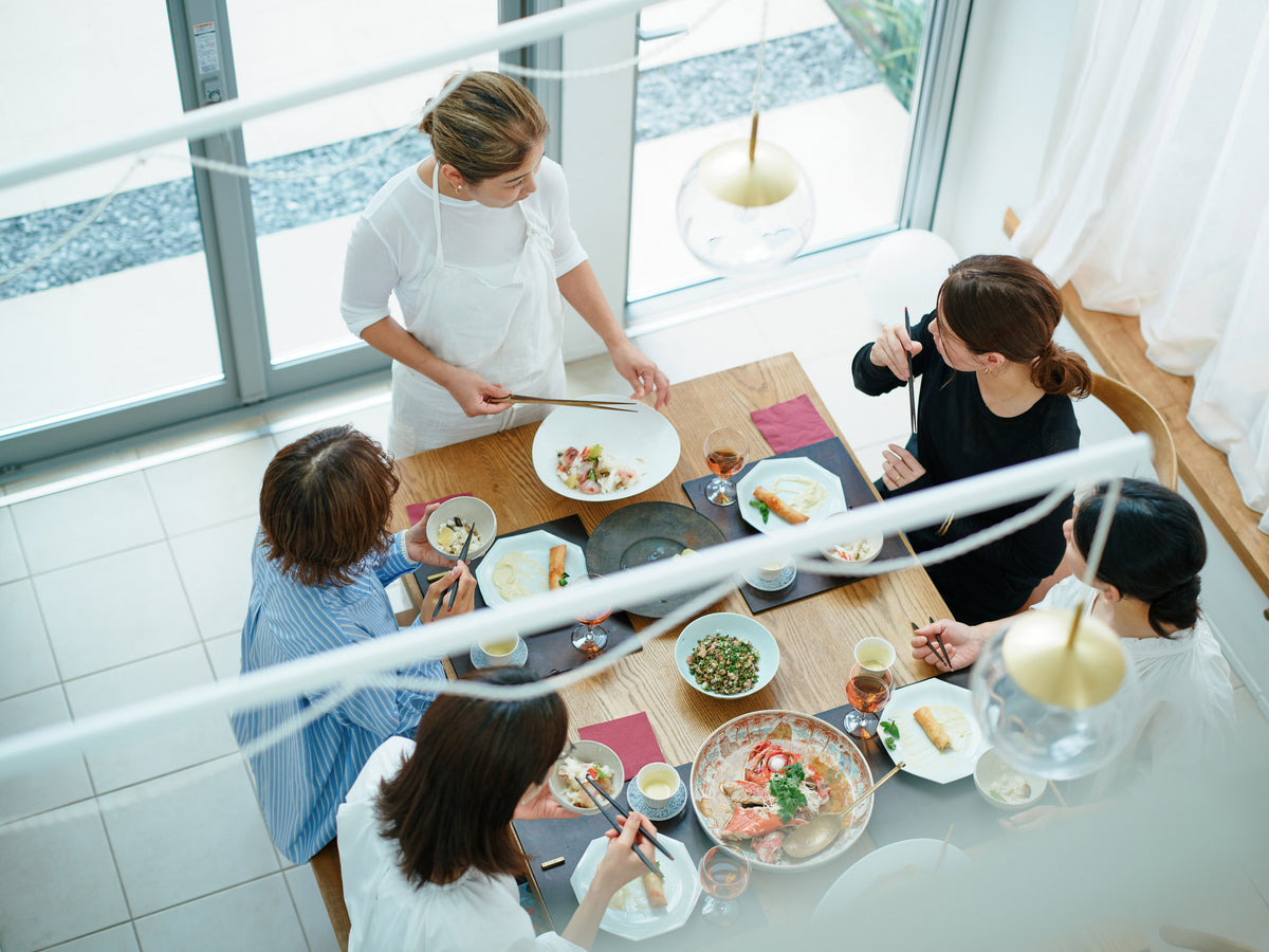 作った料理を装いながらダイニングで笑顔を見せる料理家 平林愛
